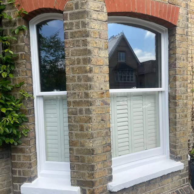 White sash windows and sills in a brick bay